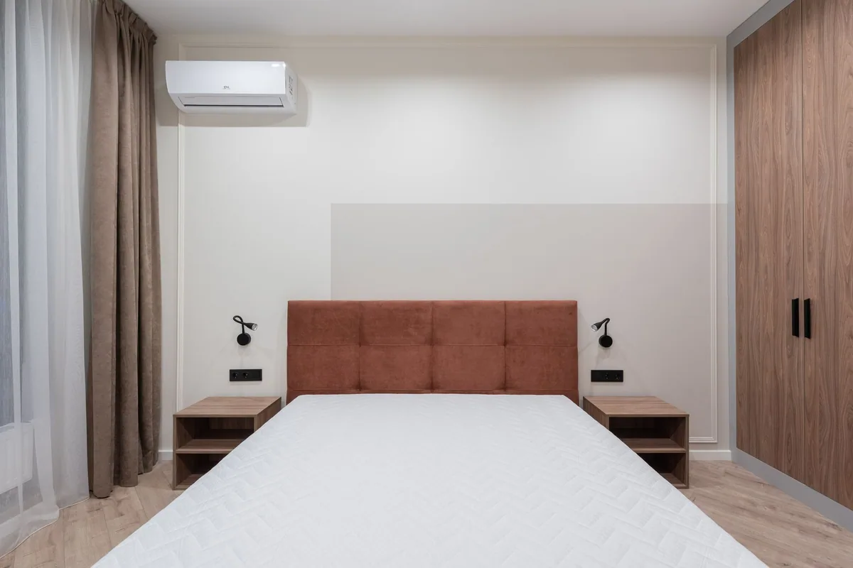 Unidad interior de un aire acondicionado split instalada en la pared de un dormitorio
