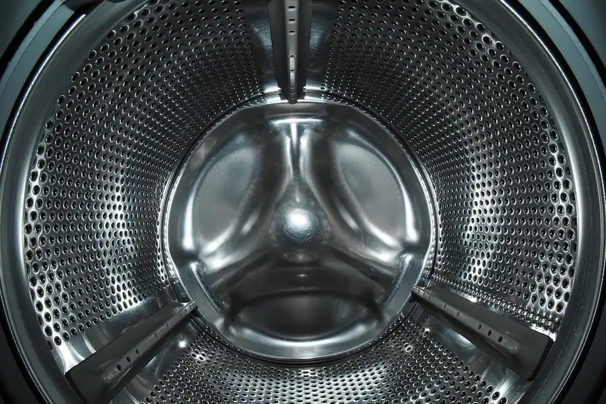 Interior del tambor de acero inoxidable de una lavadora de carga frontal, con sus tres palas